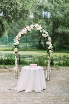 Full-length view of the arch with white flowers placed behind the table with Stock-Fotos