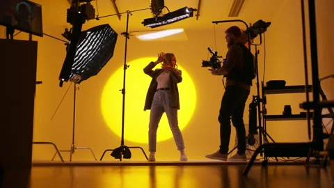 Full length view of the bearded operator taking video of dancing lady inside Stock Footage 274580688