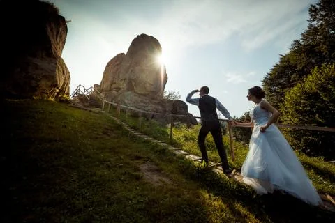 Full-length view of the elegent groom leading the beautiful young bride by the Stock Photos