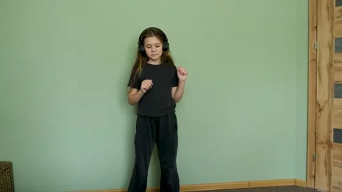 Full-length view of a joyful young girl with long hair wearing headphones Stock-Footage 330048397