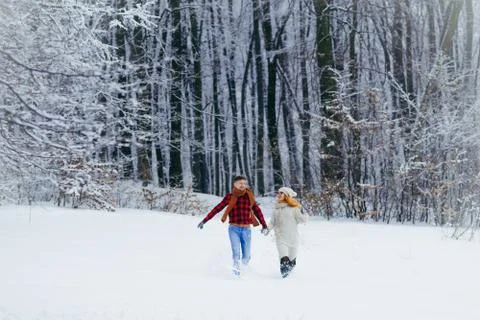Full-length view of the two happy lovers are holding hands and cheerfully Stock Photos