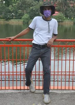 Full length of a young guy standing outside with wearing face mask during covid Stock Photos