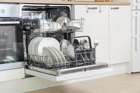 Full load dishwashing machine. Clean dishes and cutlery. convenience in the w Stock Photos