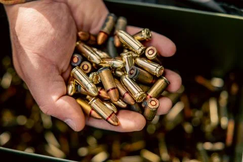 Full metal jacket ammunition held in a man's hand. many cartridges for the ma Stock Photos
