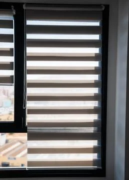 Full modern window covered with zebra roller blinds in bright daylight 스톡 사진