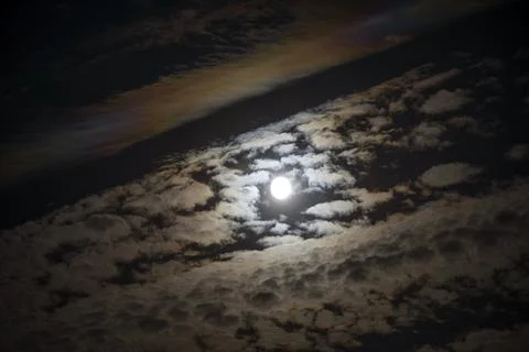 Full moon among strips of clouds on dark sky background. Stock Photos
