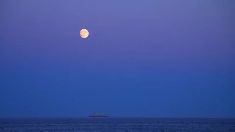 Full moon and cruise ship gliding over Atlantic Ocean from beach in Acadia Stock Footage 336296498