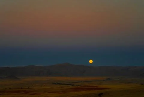 Full moon ascends over the dune in Namib desert Stock Photos