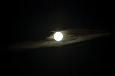 Full moon behind clouds in dark night sky Stock Photos