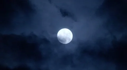 Full moon behind clouds at night Stock Footage