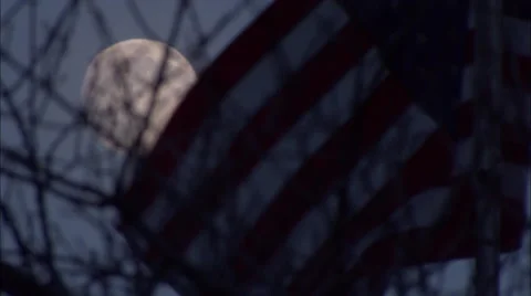 Full Moon Behind Tree Branches and American Flag HD Video Vídeo Stock 57964881