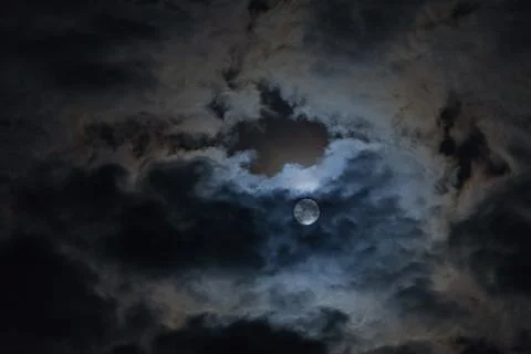Full moon in the clouds in the night sky. Stock Photos
