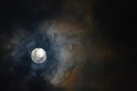 Full moon in colorful clouds with blue and amber tones Stock Photos