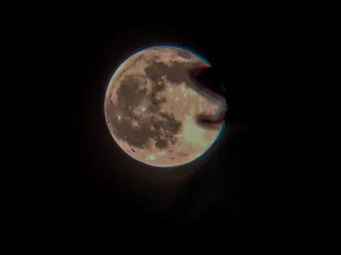 A full moon covered by dark clouds in the night sky creates a mysterious at.. Stock Photos