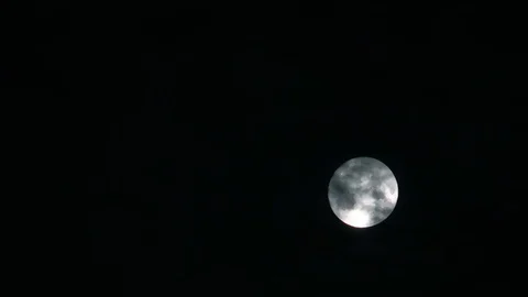 Full moon on dark cloudy night. Clouds passing by the moon in spooky Stock Footage