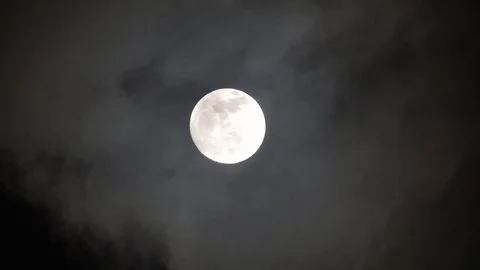 Full moon on dark cloudy night. Clouds passing by the moon, real time shot. Video stock 122693291