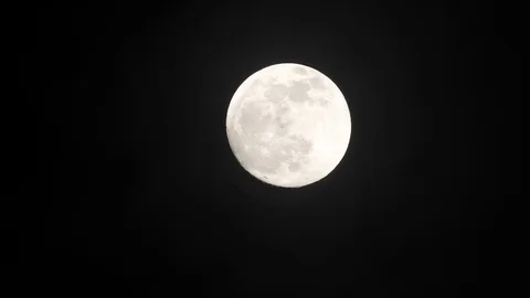Full moon on dark cloudy night. Clouds passing by the moon, real time shot. Video stock 122693380