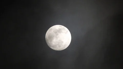 Full moon on dark cloudy night. Clouds passing by the moon, real time shot. Video stock 122693391