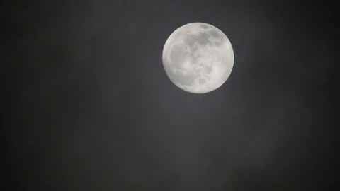 Full moon on dark cloudy night. Clouds passing by the moon, real time shot. Video stock 122693707
