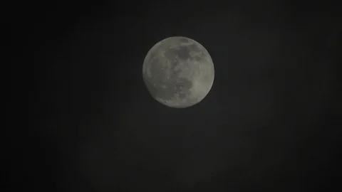 Full moon on dark cloudy night. Clouds passing by the moon, real time shot. Stock Footage 122693857