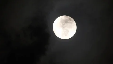 Full moon on dark cloudy night. Clouds passing by the moon, real time shot. Video stock 122693934
