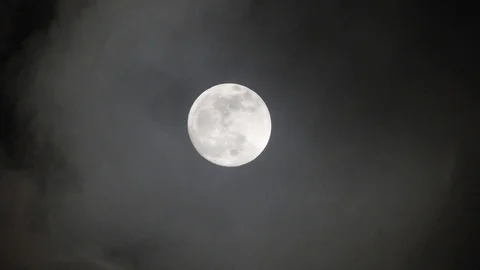 Full moon on dark cloudy night. Clouds passing by the moon, real time shot. Video stock 122693978