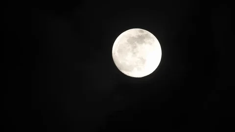 Full moon on dark cloudy night. Clouds passing by the moon, real time shot. Video stock 122693993