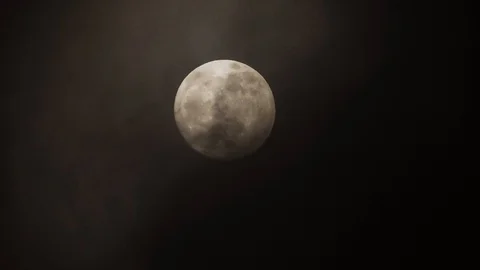 Full moon on dark cloudy night. Clouds passing by the moon, real time shot. Stock Footage 122694006
