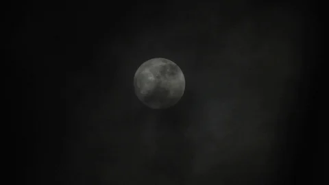 Full moon on dark cloudy night. Clouds passing by the moon, real time shot. Video stock 122694180