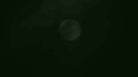 Full moon on dark cloudy night. Clouds passing by the moon, real time shot. Video stock 122694221