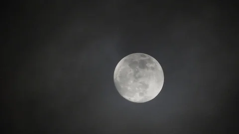 Full moon on dark cloudy night. Clouds passing by the moon, real time shot. Video stock 122694321