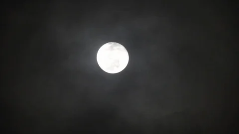 Full moon on dark cloudy night. Clouds passing by the moon, real time shot. Video stock 122694407