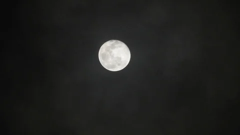Full moon on dark cloudy night. Clouds passing by the moon, real time shot. Video stock 122694480