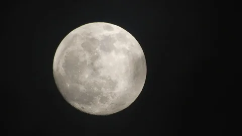 Full moon on dark cloudy night. Clouds passing by the moon, real time shot. Video stock 122694494
