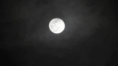 Full moon on dark cloudy night. Clouds passing by the moon, real time shot. Video stock 122694569