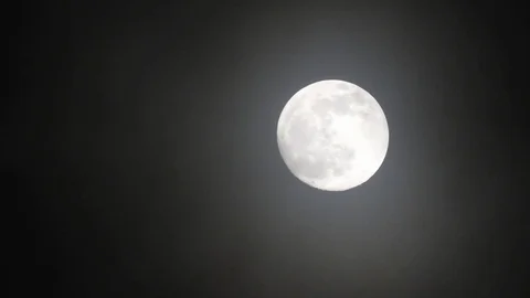 Full moon on dark cloudy night. Clouds passing by the moon, real time shot. Video stock 122694700