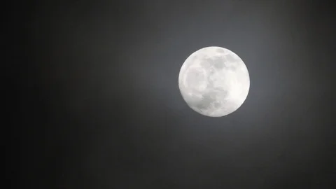 Full moon on dark cloudy night. Clouds passing by the moon, real time shot. Video stock 122694788