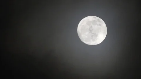 Full moon on dark cloudy night. Clouds passing by the moon, real time shot. Video stock 122694872