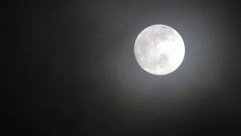 Full moon on dark cloudy night. Clouds passing by the moon, real time shot. Video stock 122694909
