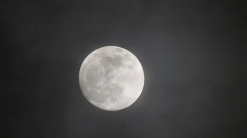 Full moon on dark cloudy night. Clouds passing by the moon, real time shot. Stock Footage 122695067