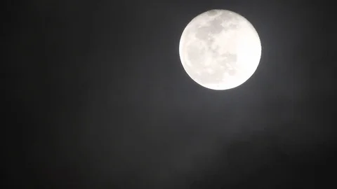 Full moon on dark cloudy night. Clouds passing by the moon, real time shot. Video stock 122695132