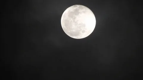Full moon on dark cloudy night. Clouds passing by the moon, real time shot. Video stock 122695199