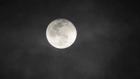 Full moon on dark cloudy night. Clouds passing by the moon, real time shot. Video stock 122695240