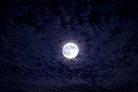 Full moon with dramatic night clouds. Moonlight on dark cloudy sky. Full moon Stock Photos