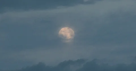 Full Moon at Dusk Behind Clouds Stock Footage 76476924