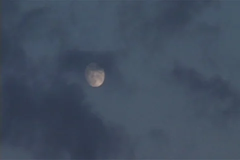 Full moon in early night sky covered by wispy clouds. 스톡 동영상 86753372
