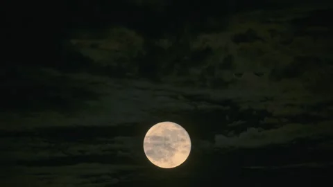 Full Moon Glowing behind Dark Clouds in Night Sky Stock Footage 344694621