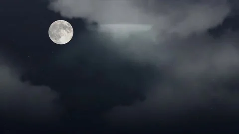 Full moon glowing brightly amidst dark drifting clouds in night sky cosmic Stock Footage 340940607