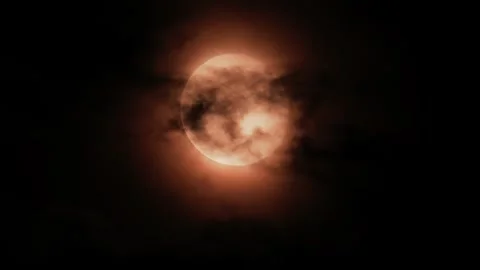 Full moon glowing through dark night clouds with red tint. Vídeo Stock 339258093