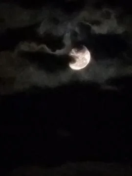 Full moon glowing through dramatic night clouds Stock Photos